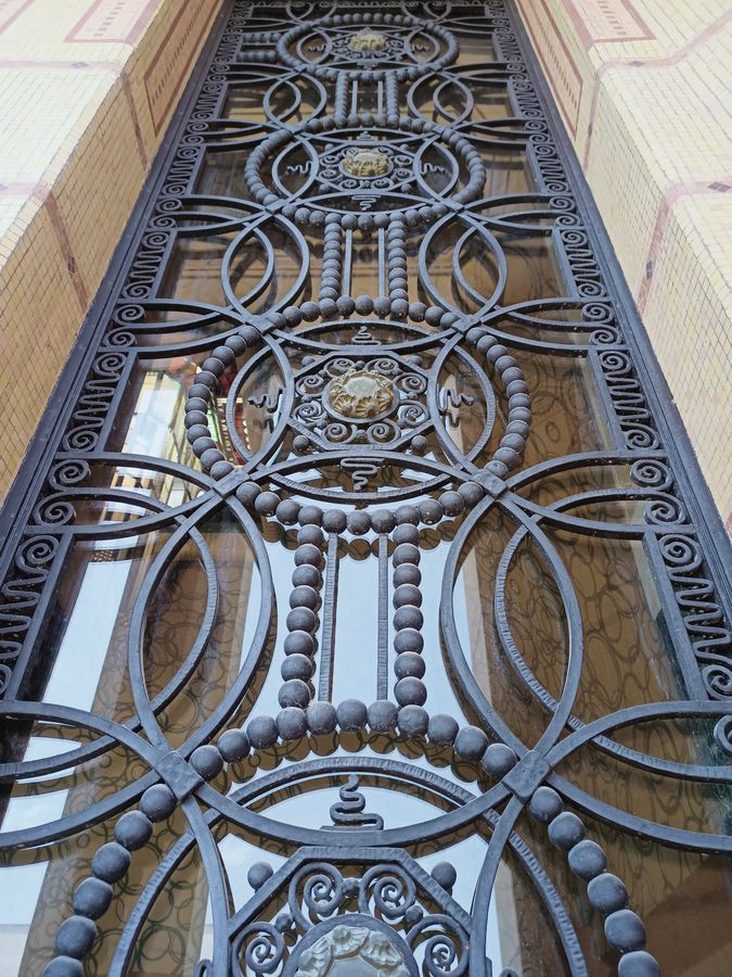 Septembre 2025 - Losanges, cercles et perles de la porte d’entrée en fer forgé de la bibliothèque Carnegie conçue par les établissements Schwartz-Haumont